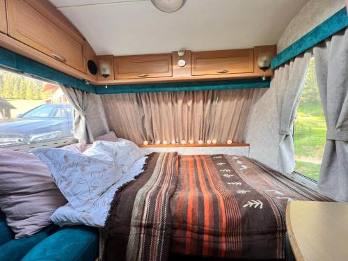 a bed in the back of an rv at Padiș-Glăvoi Camper-van in Pietroasa