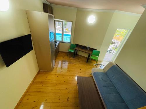 a living room with a blue couch and a table at Calligraphy Hotel and Cottages in Mtsvane Kontskhi