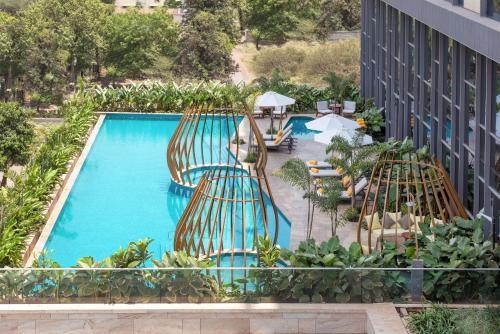 een uitzicht over een zwembad met stoelen en tafels bij Radisson Blu Hotel & Spa, Nashik in Nashik