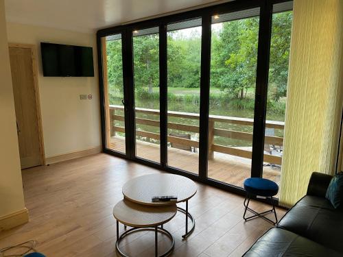 a living room with a couch and a table at Cackle hill lakes, Kingfisher Lodge in Biddenden