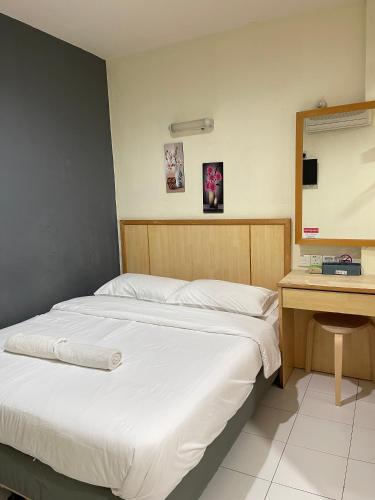 a bedroom with two beds and a desk with a mirror at Fresh Hotel Falim in Ipoh