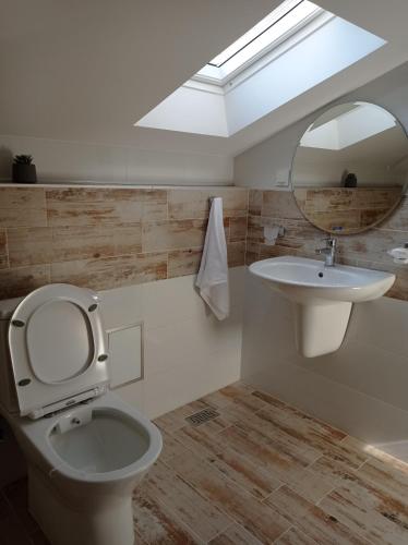 a bathroom with a toilet and a sink at Къща за гости-Ганеви in Zmeitsa