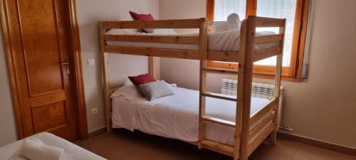 1 dormitorio con 2 literas y ventana en HOSTAL RURAL CAL XIC Saldes, en Saldes