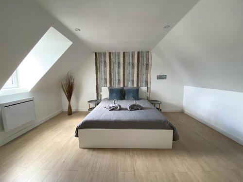 a bedroom with a bed and a large window at Les petits galets - T2 - WIFI - Coeur de ville - Parking in Pont-lʼAbbé