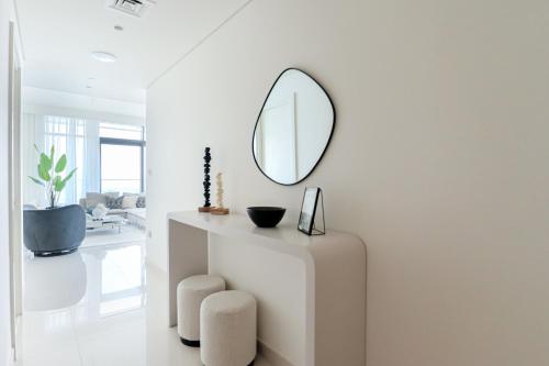 a white room with a mirror and a table at HiGuests - Superlative apt with private beach access in Dubai