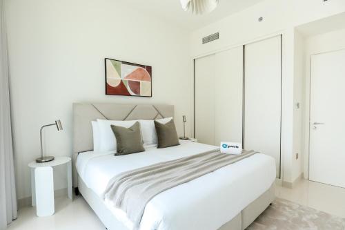 a white bedroom with a large white bed in it at HiGuests - Superlative apt with private beach access in Dubai