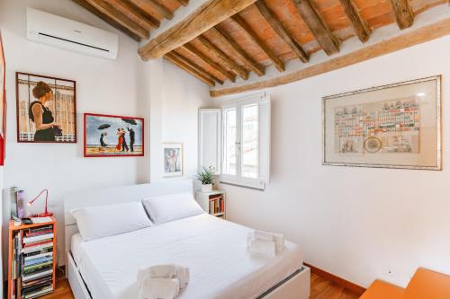 a white bedroom with two beds in it at Piazza dei Cavalieri Orange Attic Apartment in Pisa