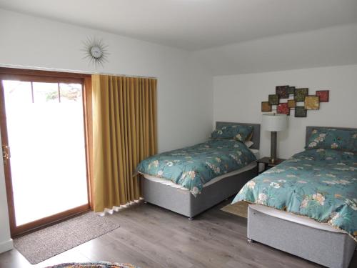 a bedroom with two beds and a window at Braeview Studio in Macduff