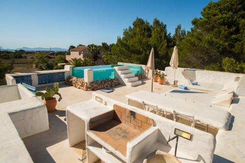 eine Terrasse mit Tischen, Stühlen und Sonnenschirmen in der Unterkunft CA'N COMEDIANT in Sant Ferran de Ses Roques