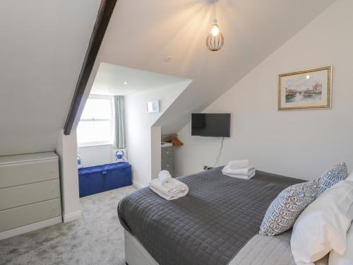 a attic bedroom with a bed and a television at Foxton Penthouse in Whitby