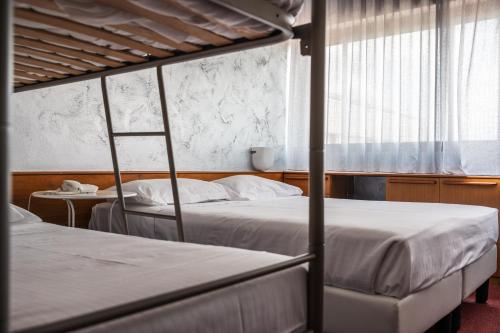 a bedroom with two bunk beds and a window at Hotel Valpolicella International in San Pietro in Cariano