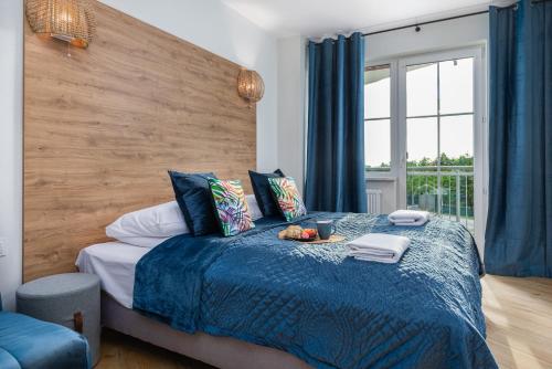 Schlafzimmer mit einem Bett mit blauer Decke in der Unterkunft Zielona Apartment Grzybowo by Renters in Grzybowo