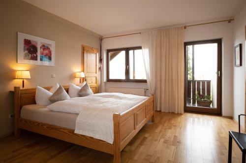 een slaapkamer met een groot bed en 2 ramen bij Gästehaus Heintz in Merzig