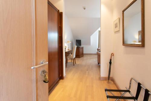 a hallway with a door and a chair and a table at Hotel Restaurant Krone in Hayna