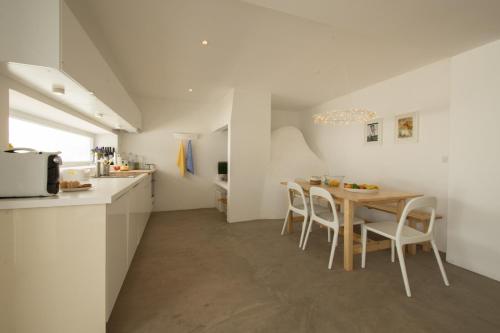 a kitchen and dining room with a table and chairs at CASASUPERTUBOS - Villa 9 in Peniche