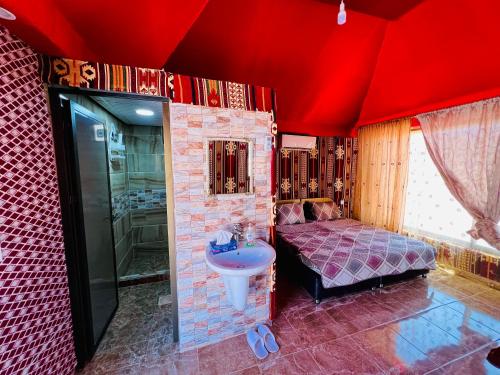 a bedroom with a bed and a sink and a shower at Shakria Bedouin Life Camp in Wadi Rum