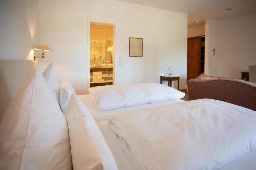 two beds in a room with white sheets at Hotel Restaurant Krone in Hayna
