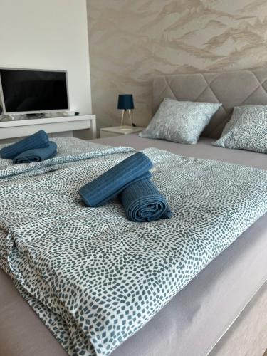 a bed with two blue pillows on top of it at Lakeside Home in Siófok