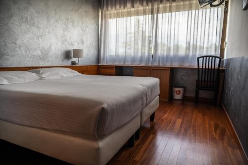 a bedroom with a large bed and a window at Hotel Valpolicella International in San Pietro in Cariano