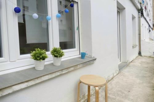 a window sill with three potted plants and a stool at Apartamento Pamplona 1 in Pamplona