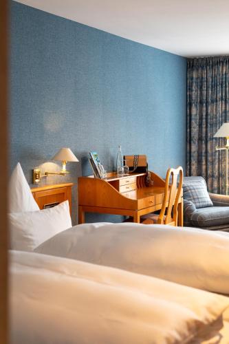 a bedroom with a bed and a desk and a chair at Hotel Restaurant Krone in Hayna
