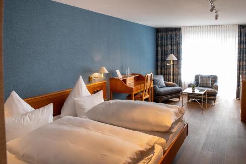 a hotel room with two beds and a desk at Hotel Restaurant Krone in Hayna