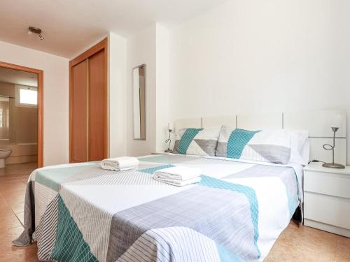 a bedroom with a large bed with two towels on it at Algaba planta Baja C in La Algaba