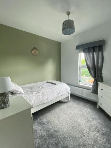 a bedroom with a bed and a window at Gorgeous 3 Bedroom Victorian Townhouse in Lisburn