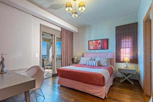 Domus Eleon Luxury Villa في مدينة ريثيمنو: غرفة نوم بسرير وطاولة ومكتب