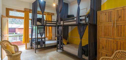 a room with two bunk beds in a house at Whoopers Hostel Kasol in Kasol