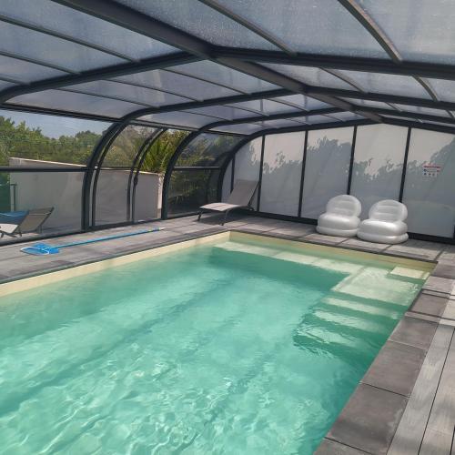 - une piscine avec toit rétractable dans l'établissement Maison de Vacances - Vue mer avec Piscine, à Carantec