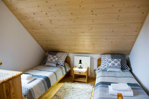 a room with two beds in a attic at Willa Basinek in Muszyna