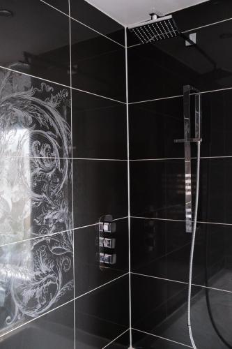 a black tile bathroom with a dragon mural on the wall at Gorgeous 3 Bedroom Victorian Townhouse in Lisburn