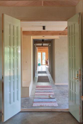 a hallway in a house with a rug on the floor at Pinewood Guesthouse in Mäntsälä