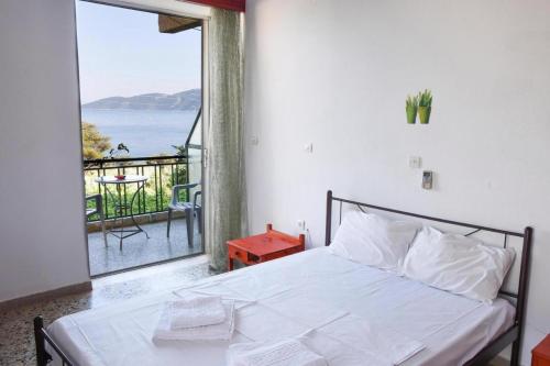 Hotel Korfos - Ξενοδοχείο Κόρφος Renovated في كورفوس: غرفة نوم مع سرير وإطلالة على المحيط