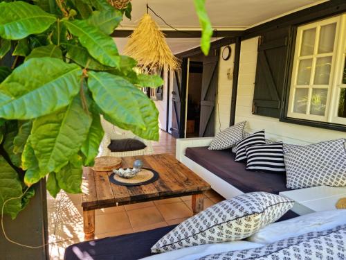 un patio con almohadas y una mesa en un porche en Villa54, en La Saline-Les-Bains