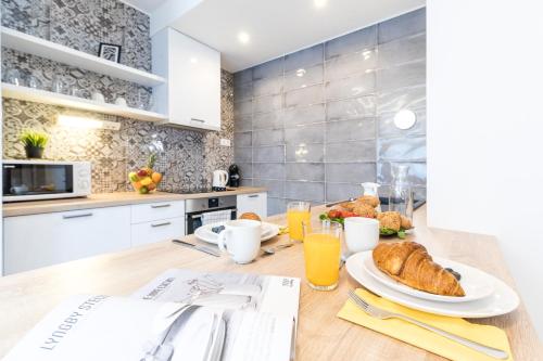 a kitchen with a table with bread and orange juice at Vagabond Corvin in Budapest