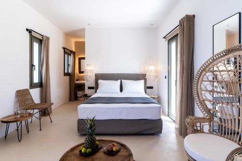 a bedroom with a bed and a table and chairs at PAREA Paros - Adults Only in Kampos Paros