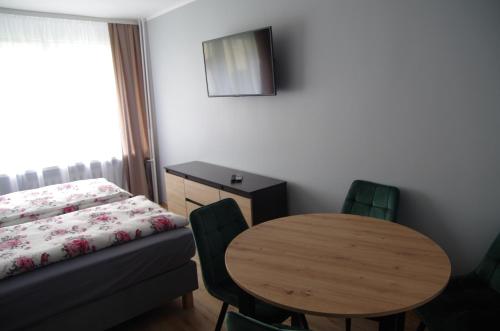 a room with a table and a bed and a table and chairs at Apartament Cesarski in Wałcz