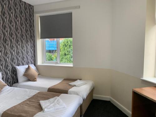 a hotel room with two beds and a window at Imperial Salford Hotel in Manchester