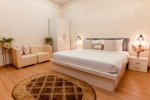a bedroom with a large white bed and a couch at Silver Leaf Apartments in Amritsar