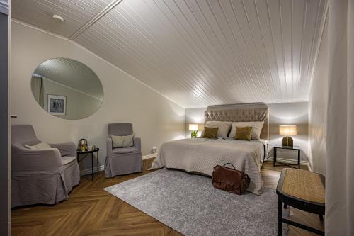 a bedroom with a bed and a mirror and a chair at Tukkilan Tila in Porvoo