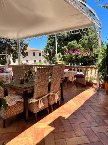 eine Terrasse mit einem Tisch und Stühlen unter einem Pavillon in der Unterkunft Villa Regina Accommodation in Santa Domenica