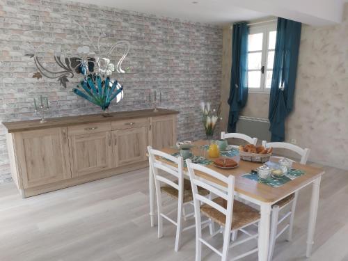 a dining room with a wooden table and chairs at le bonheur des plumes in Montmartin-en-Graignes