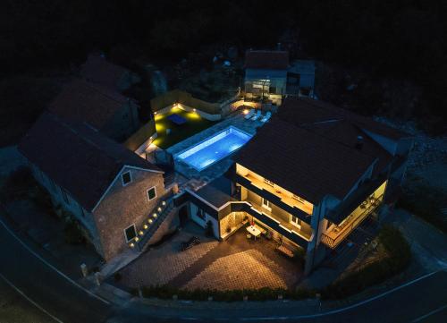 een bovenaanzicht van een huis met een zwembad bij Villa DUKA with heated private pool, Makarska region in Petričevići
