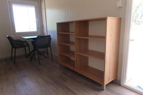 a bookcase in a room with a table and chairs at Robinson olive tree huts in Čara