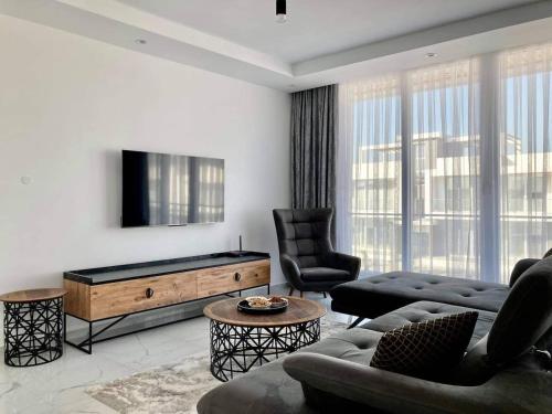 ein Wohnzimmer mit einem Sofa und einem Flachbild-TV in der Unterkunft Luxury 2-bedroom condo with a private rooftop area in Boghaz