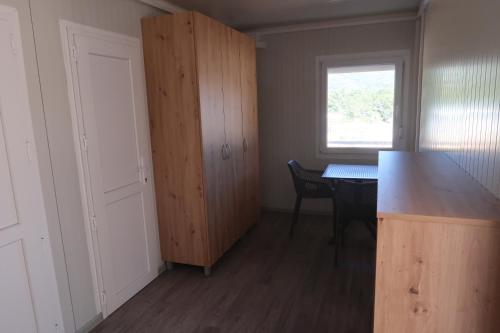 an empty kitchen with a table and a window at Robinson olive tree huts in Čara