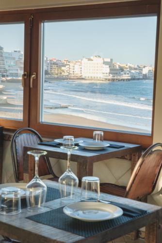 a table with wine glasses and a view of the ocean at Playa Surf CBbC Hotel in El Médano