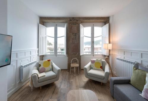 a living room with two chairs and a couch at Apartamentos Bestarruza in Mugardos